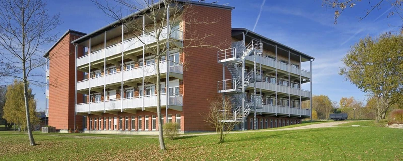 Au&szlig;enaufnahme der Geb&auml;udefront der Psychosomatischen Klinik Windach, Fachkliniken Oberberg, in Windach bei Ammersee mit Gr&uuml;nfl&auml;che im Vordergrund bei blauem Himmel
