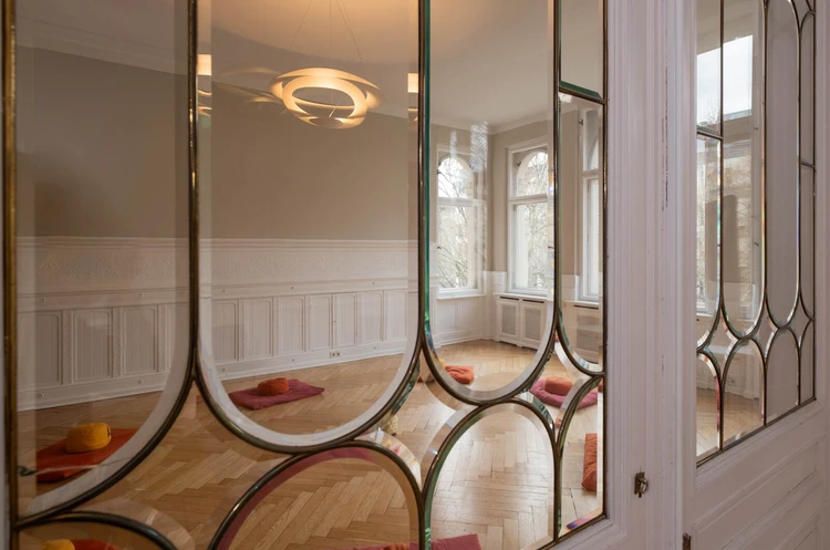 Oberberg Tagesklinik Berlin K&uuml;rf&uuml;rstendamm Blick durch Glast&uuml;r in einen gro&szlig;en Raum mit Sitzkissen auf dem Boden